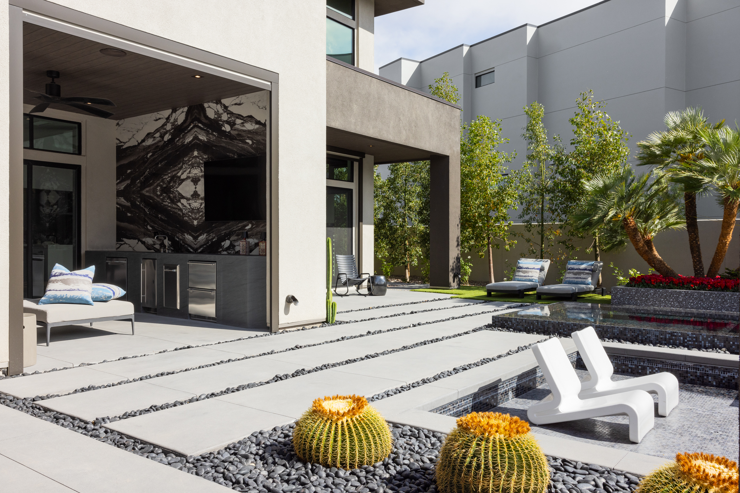 Indoor-outdoor patio with reflecting pool, barrel cactus, and lounge seating