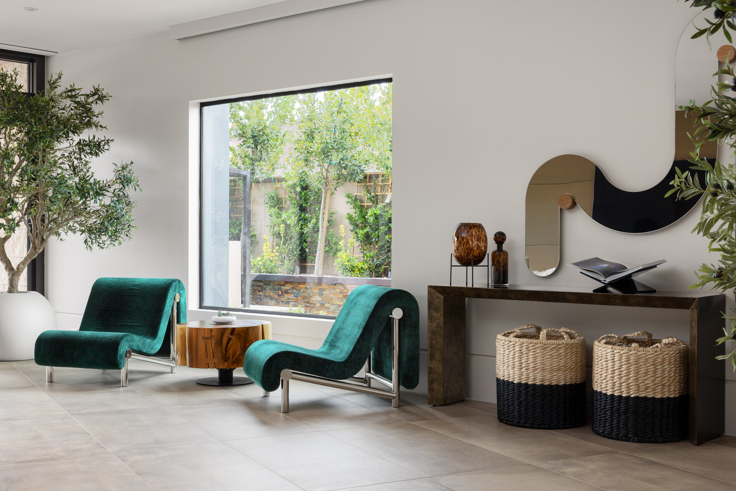 Sanctuary Peak sitting area with green velvet chairs and sculptural mirror